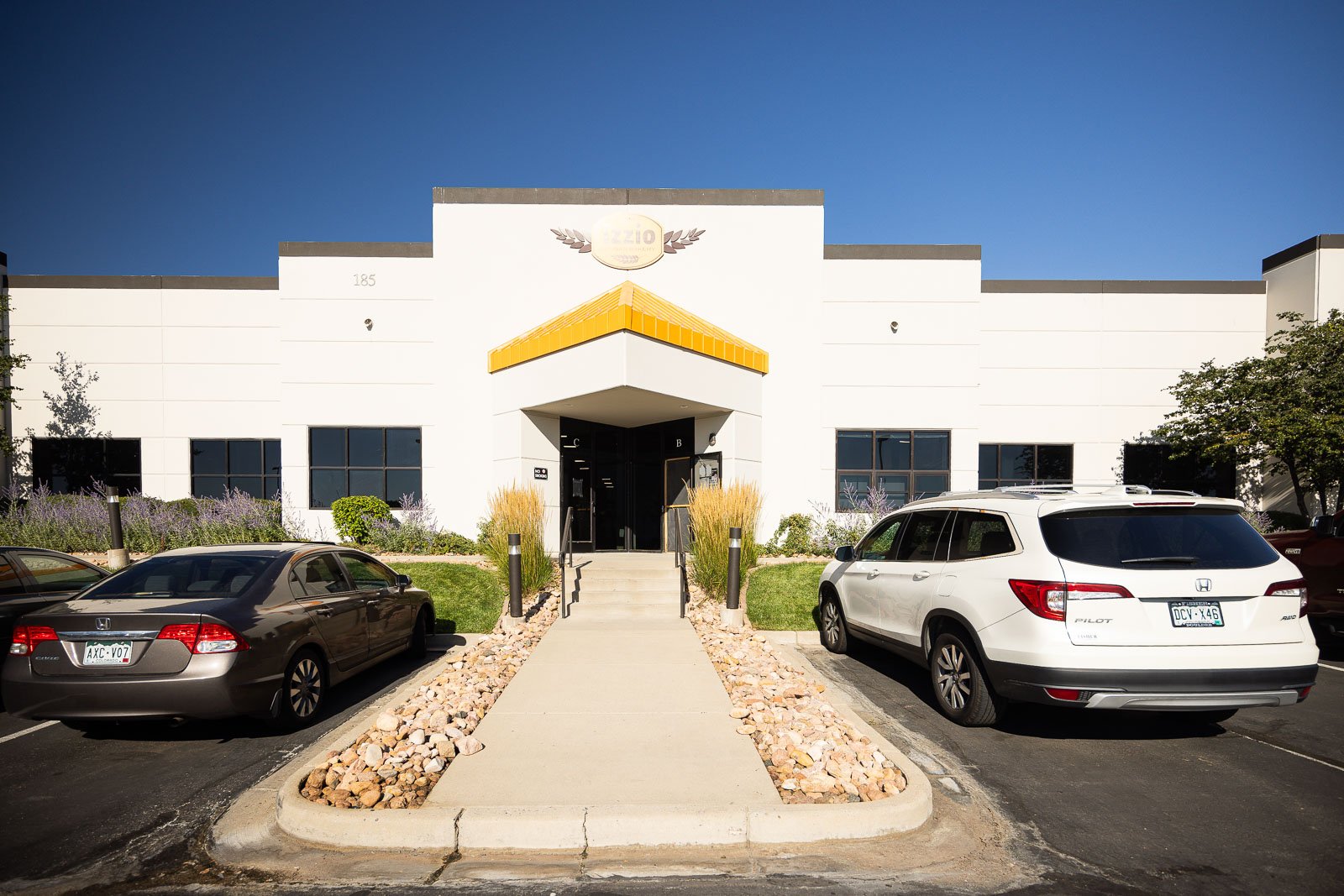 an entrance and parking spots of well-maintained commercial property