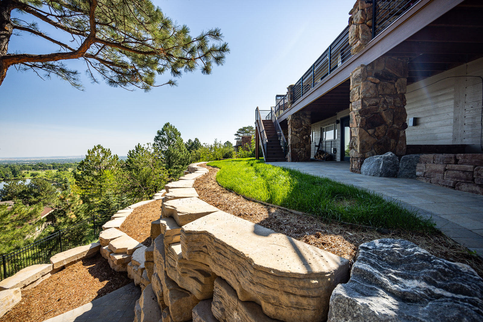 residential landscape design boulder retaining wall steps and deck