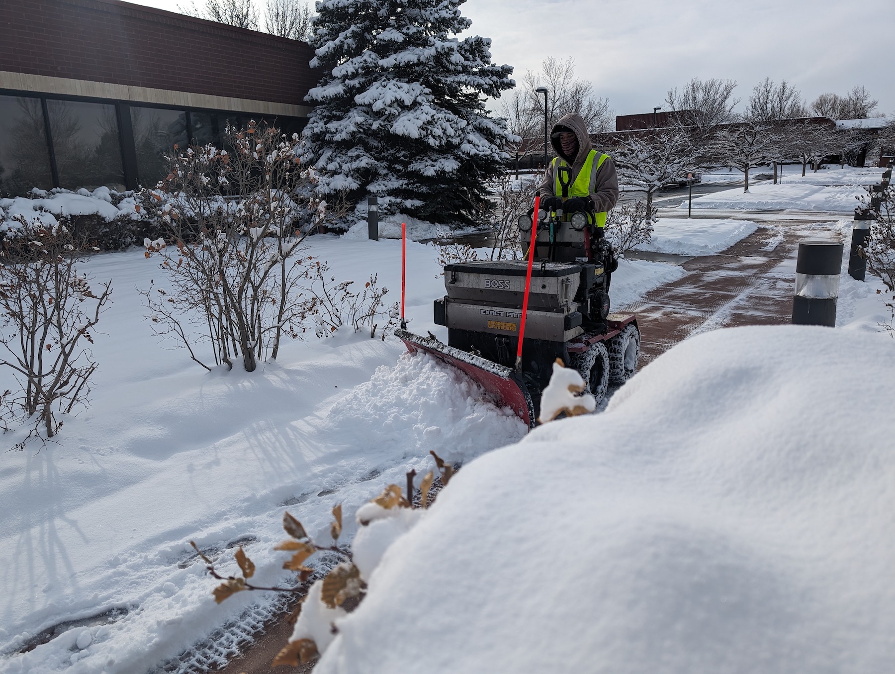 crew removing snow with snow blower on sidewalks 