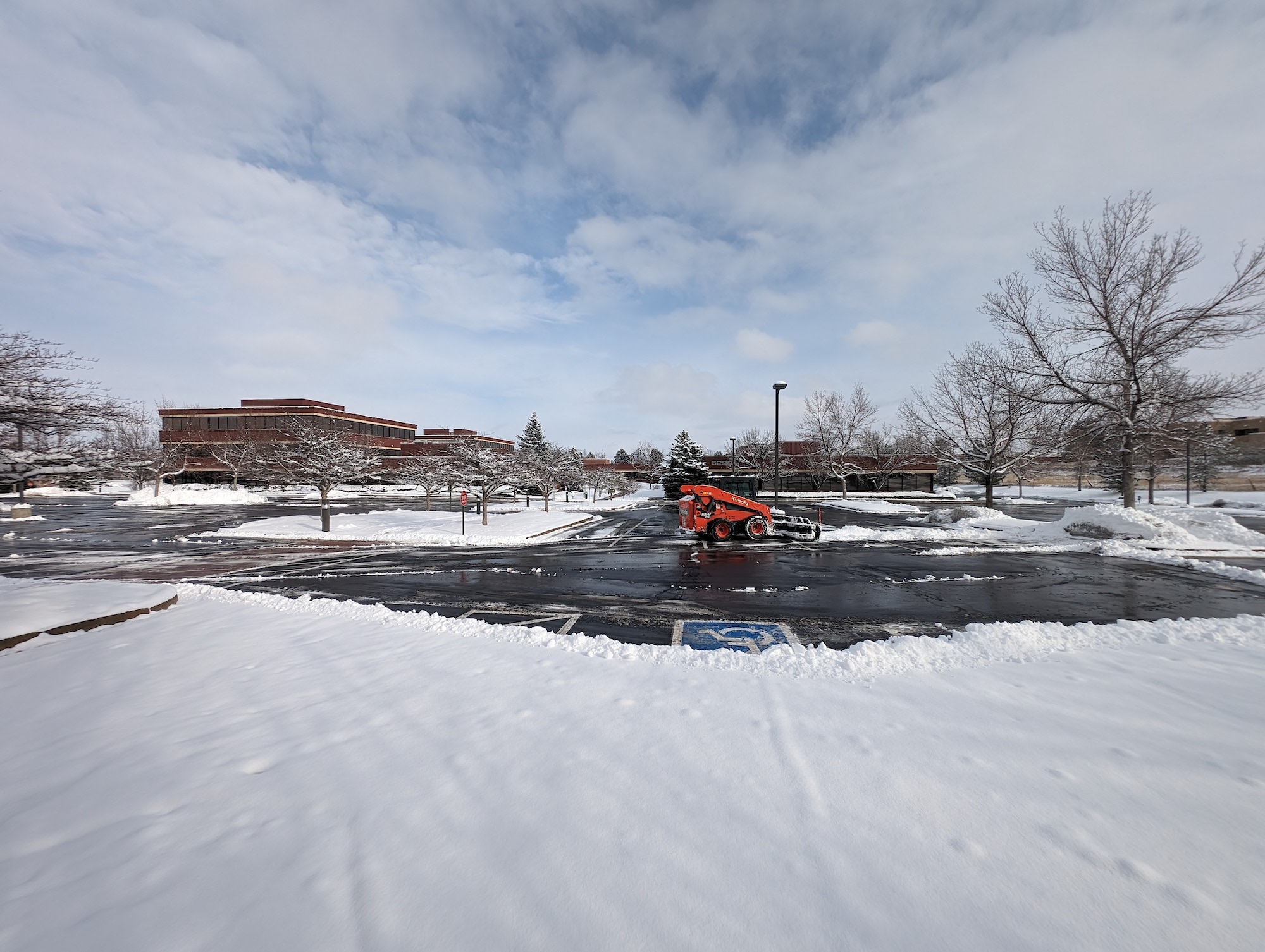 snow plow removing snow from large parking lot